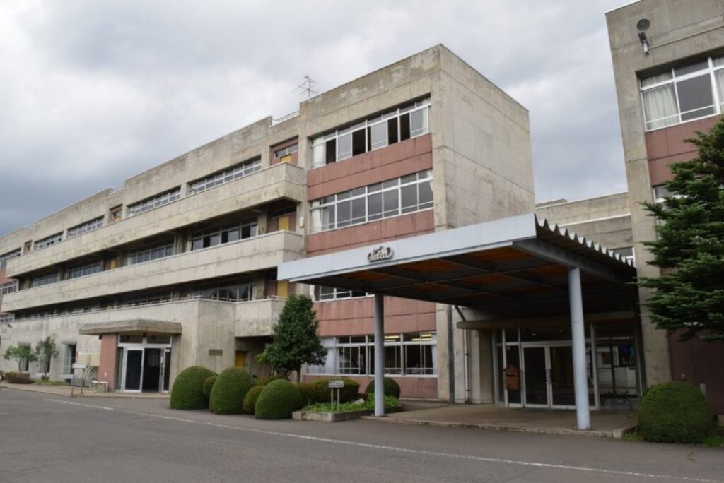 弘前学院聖愛高等学校　男子制服 聖愛の正面玄関には、制服を着たマネキンが立っています。 外から見る