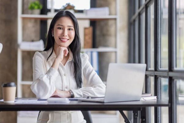 PCの前で微笑む女性