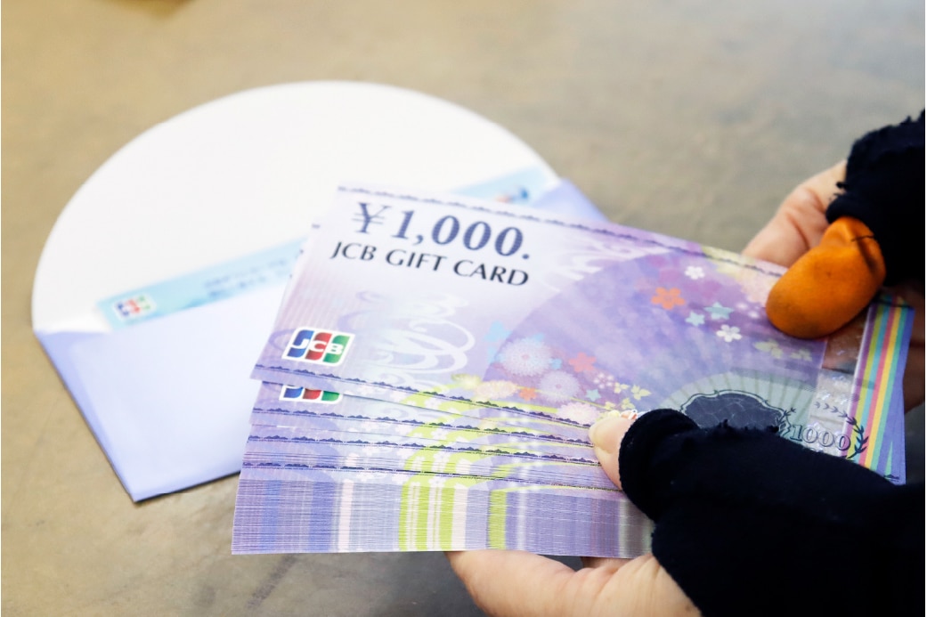 株式会社アテナの金券を取り扱う手元の写真