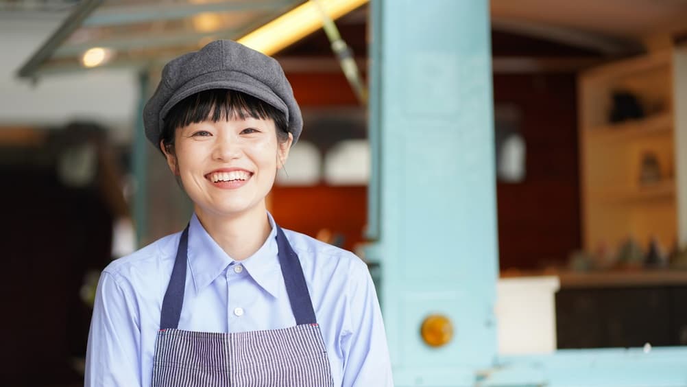 笑顔でお店に立つ女性店員