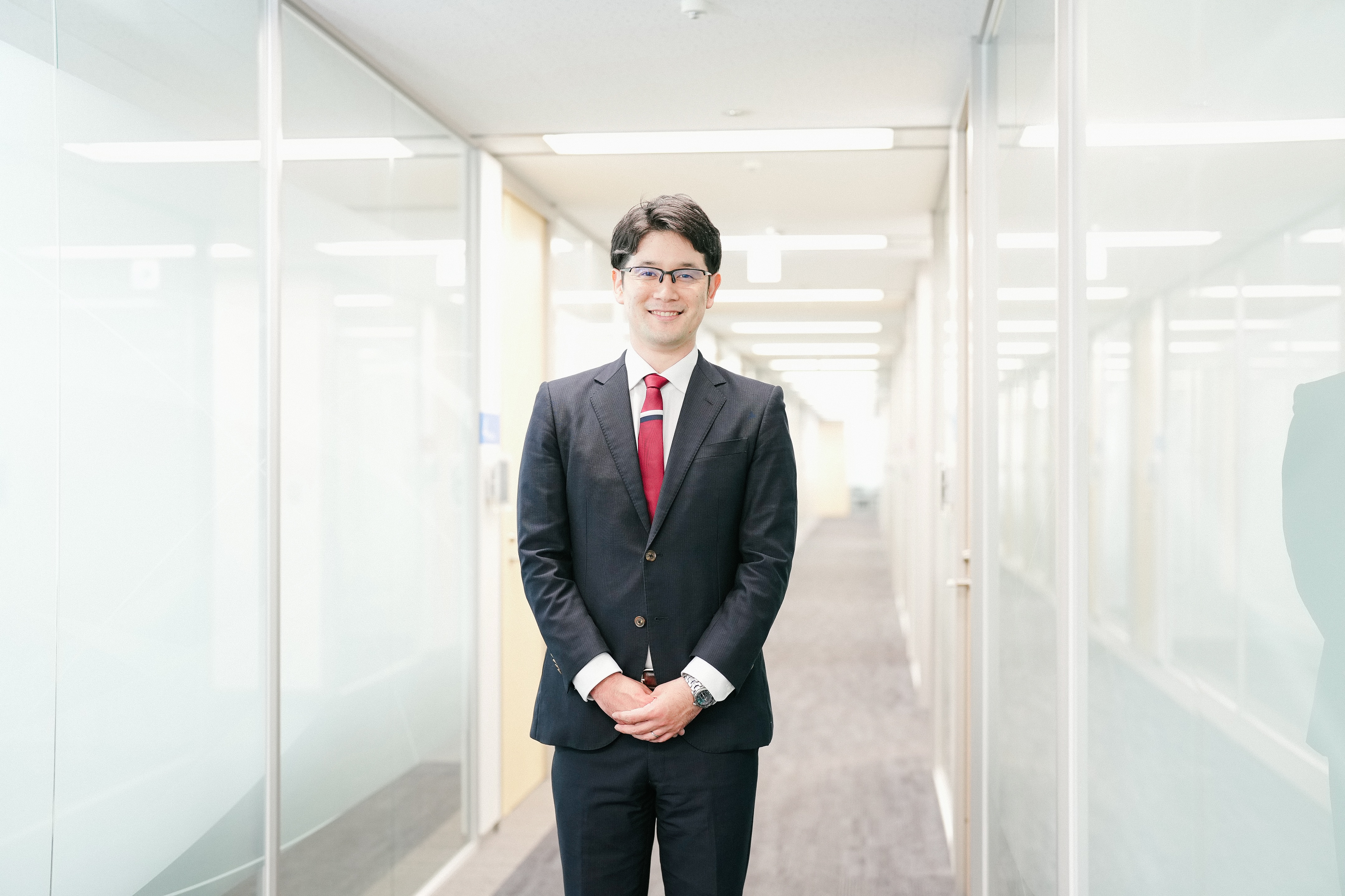 廊下に立っている、治験事務局担当者（SMA）のHさん