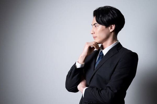 顎に手を置く男性