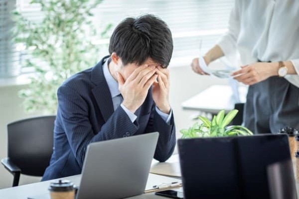 	目頭を押さえる男性