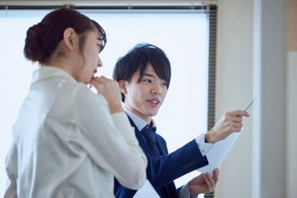 ホワイトボード前で話す社員