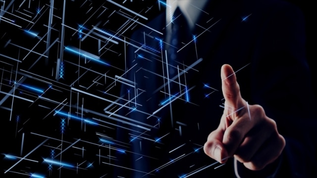 スーツ姿の男性が何かを指さしている写真