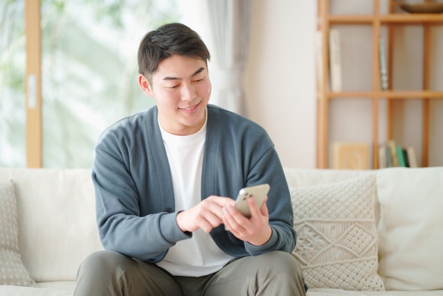 スマホを触る男性の写真