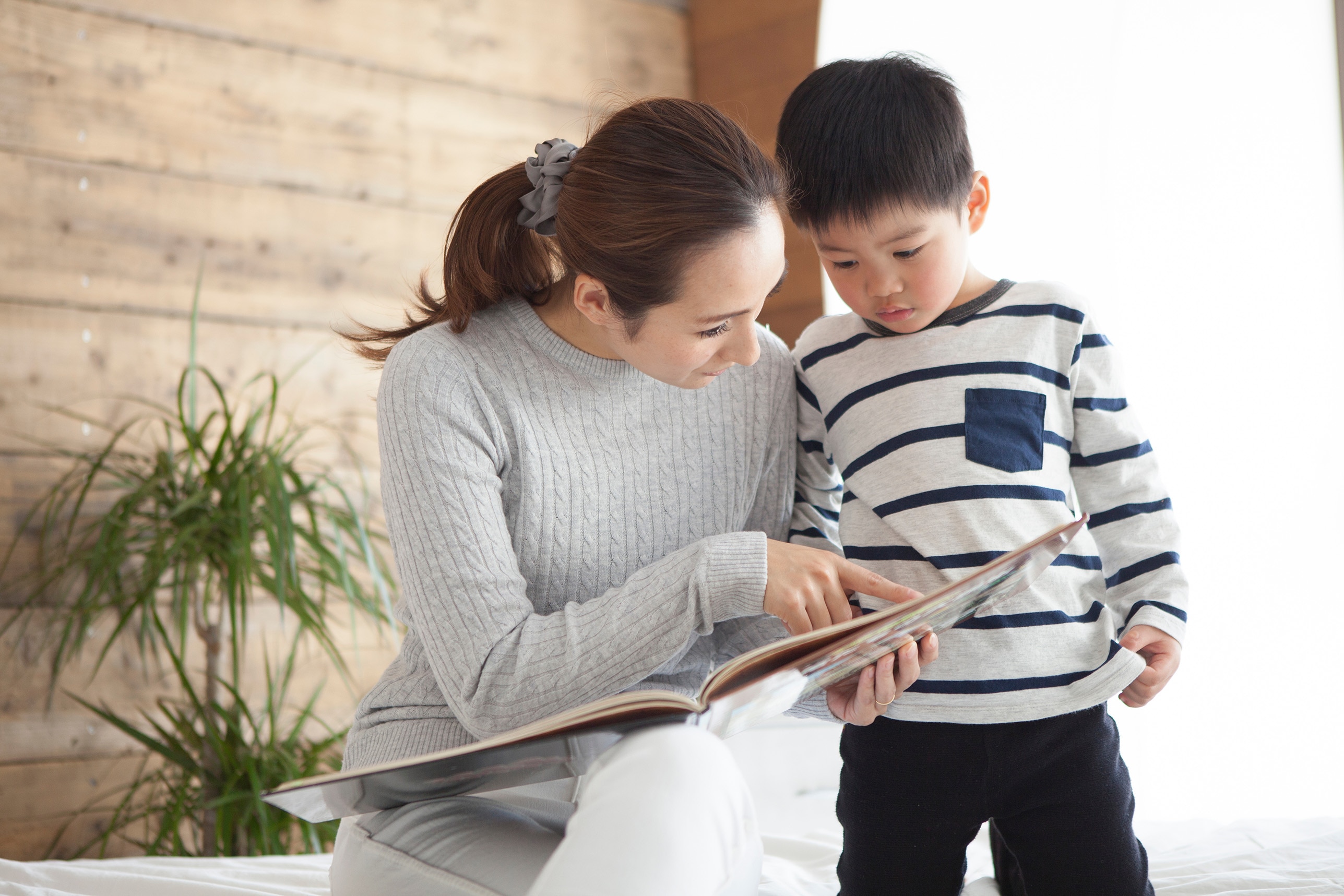 母親が息子に絵本を読み聞かせている写真