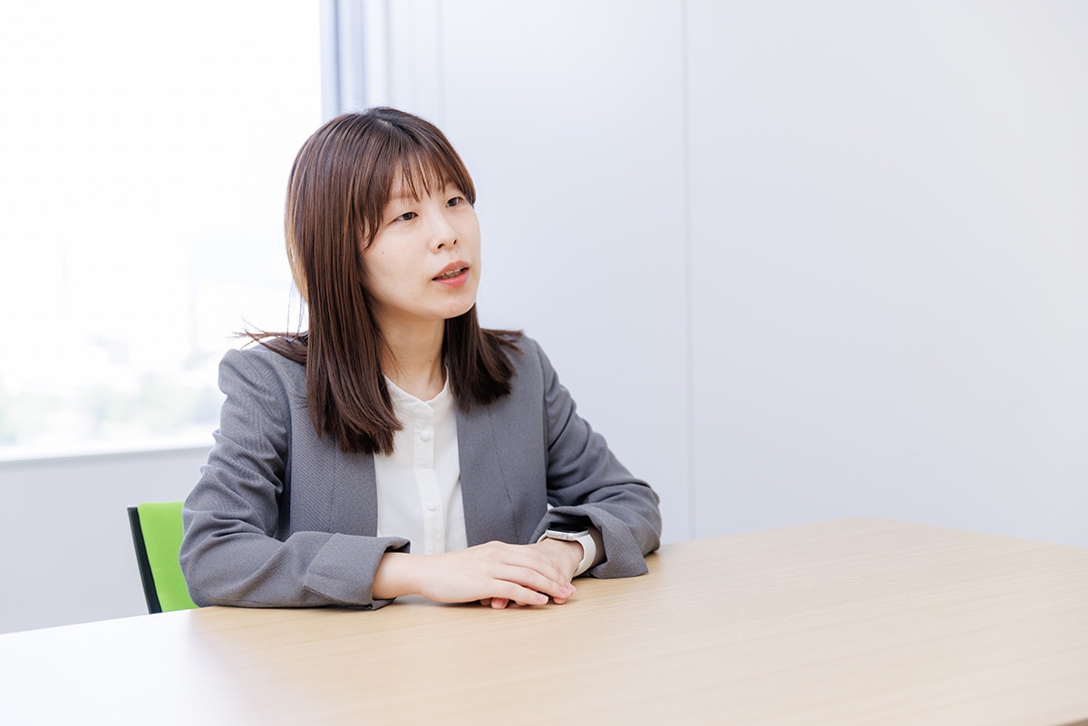 会議室で座って業務内容を説明している、治験コーディネーター（CRC）のOさん