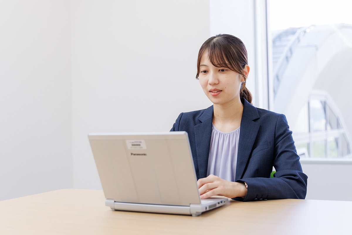 広島オフィスの会議室でPC作業をしている、治験コーディネーター（CRC）のTさん