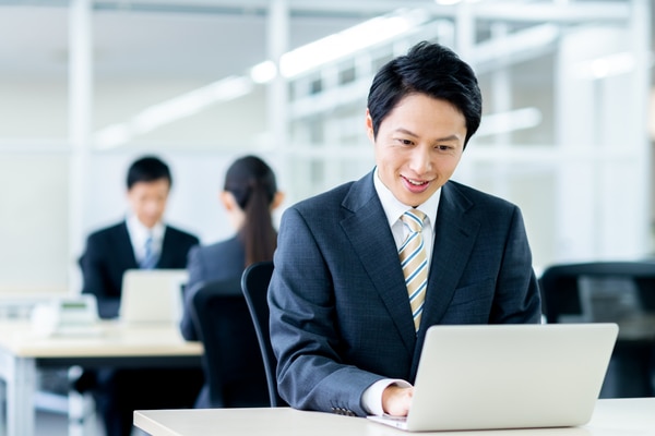 オフィスでノートPCを操作する人物
