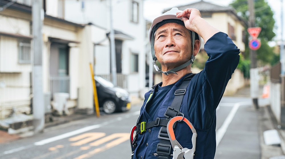建物の様子を見ている電気工事会社オーナーのイメージ画像