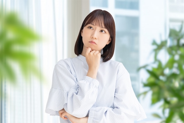 悩む仕草の女性