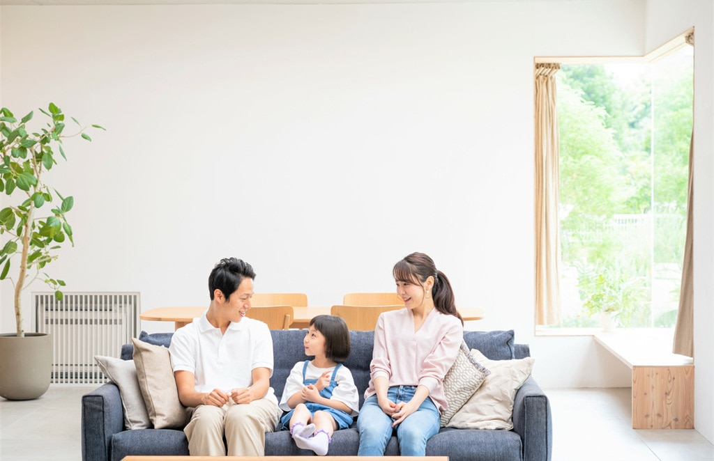 夫婦と娘がソファに座っている写真