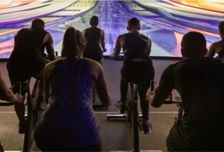 未来都市などの非日常空間を走り抜ける「暗闇バイクスタジオーTHE TRIP」映像×音楽で楽しく脂肪燃焼できます