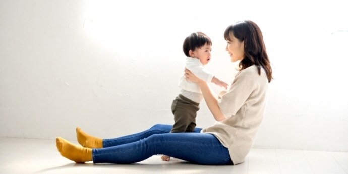 女性活躍推進 仕事と育児の両立イメージ。室内で子どもと過ごす場面を通じて、仕事と育児の両立やタイムマネジメントを表現した写真。