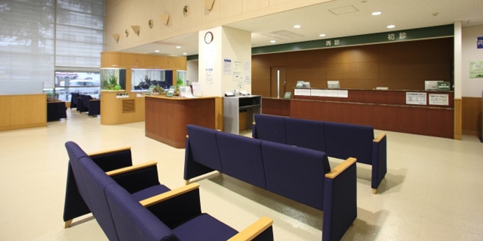 院内ヒアリング＆フォロー研修イメージ。医療施設の受付と待合室の様子、課題抽出と改善を行う研修を表現。