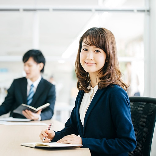 パソナHRソリューションの女性活躍推進研修ページへのリンクイメージ。会議室でノートを取りながら研修や打ち合わせに参加するビジネスシーン。