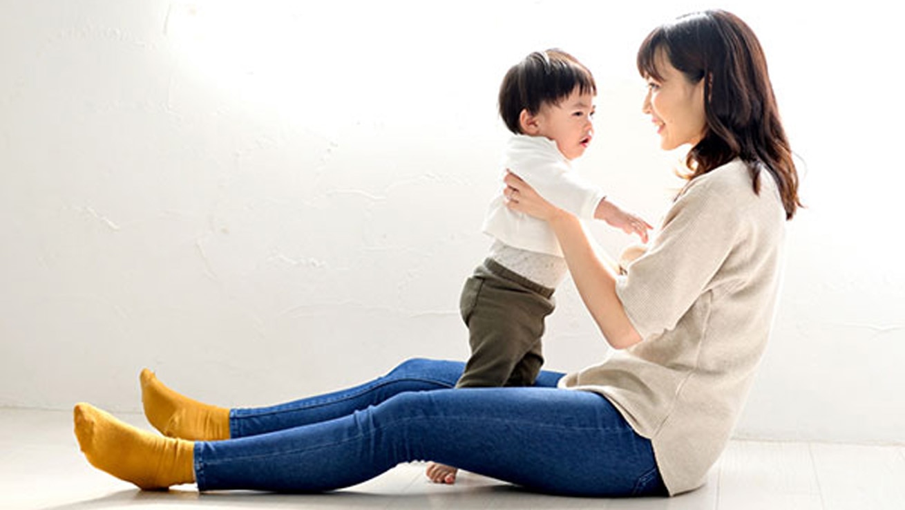 女性活躍推進 仕事と育児の両立イメージ。室内で子どもと過ごす場面を通じて、仕事と育児の両立やタイムマネジメントを表現した写真。