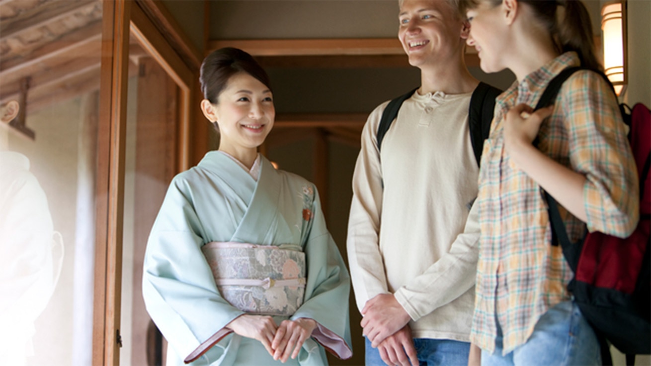 おもてなしランゲージ®英語研修イメージ。日本の伝統的な空間で着物姿の女性が外国人訪問者に対応する場面を象徴する写真。