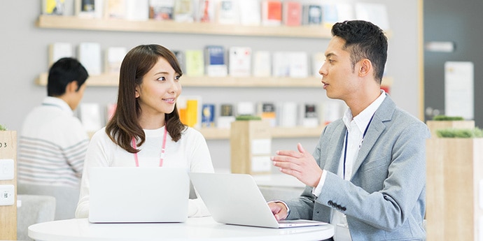 女性活躍推進研修 女性社員のマネジメント（上司向け）のメインイメージ。ノートパソコンを使って女性部下の育成やマネジメントを行っている場面。