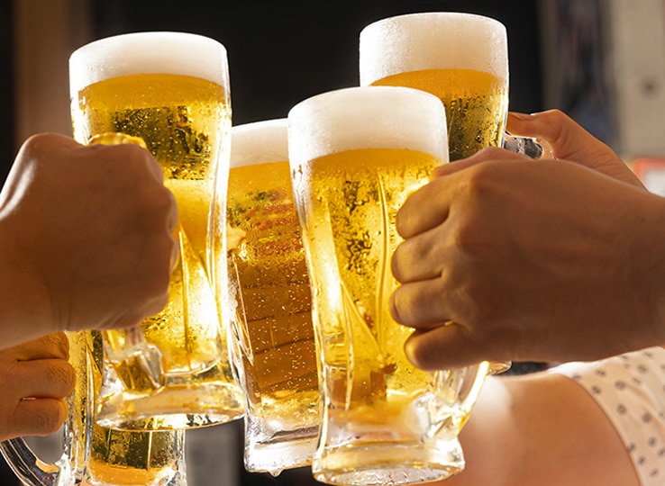 ビールジョッキを持って乾杯している様子。