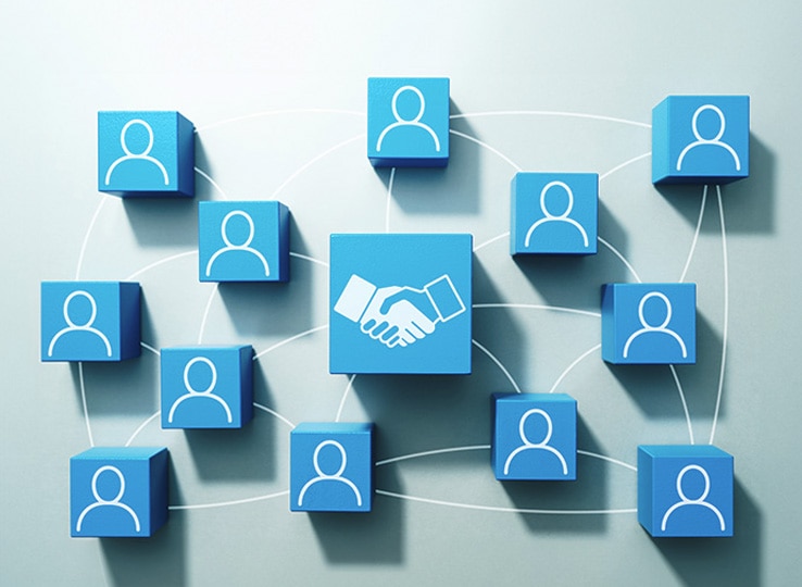 青い立方体に人物アイコンが描かれた複数のブロックがネットワーク状に配置されているイメージ。