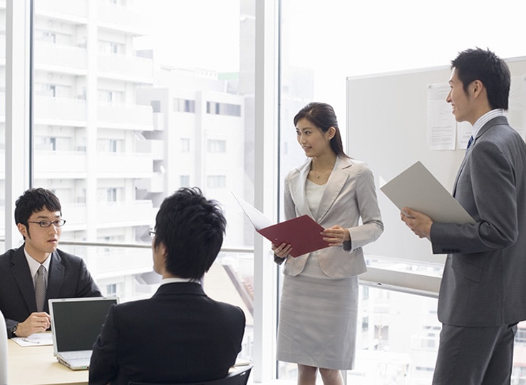 4人のビジネスマンが会議室で会議をしている様子。