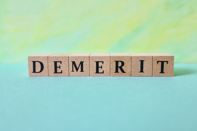 DEMERIT と書かれた木製ブロックの画像