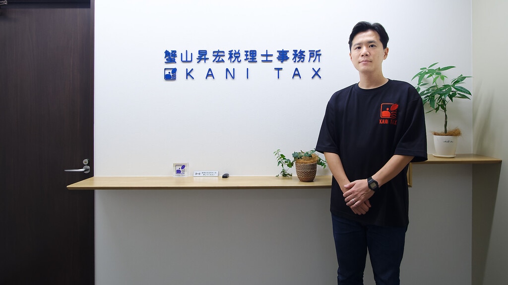 事務所入り口に立つ蟹山昇宏税理士事務所 代表 蟹山 昇宏様代表