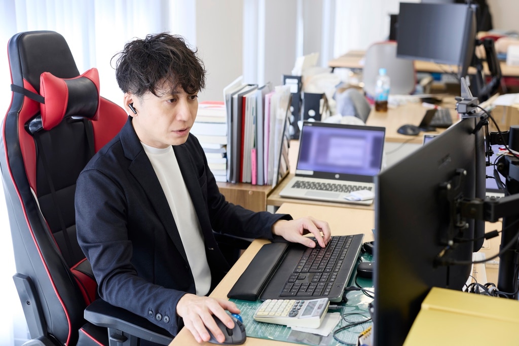 PC画面を見つめ業務に集中するBIZARQ株式会社 代表 吉岡和樹様