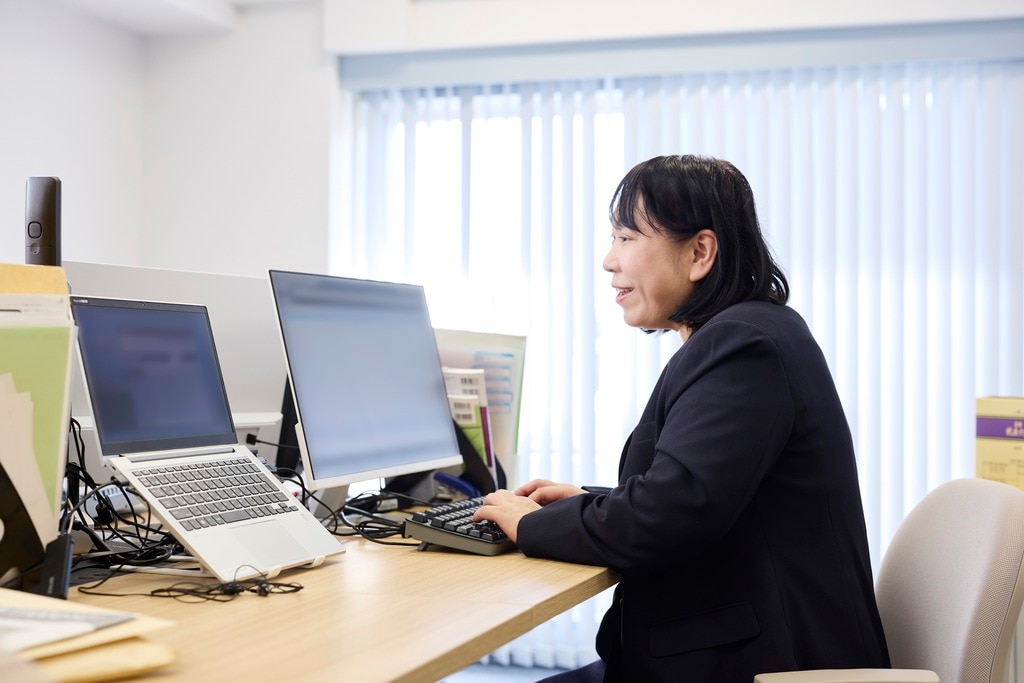 BIZARQ株式会社 柳沼理子様がPCで作業。freee会計を活用し、記帳作業が半減した現場の様子。