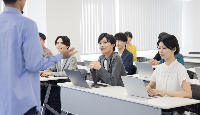 講師が話すのを聞きながら、机上のノートPCに向かう複数の受講生の写真。