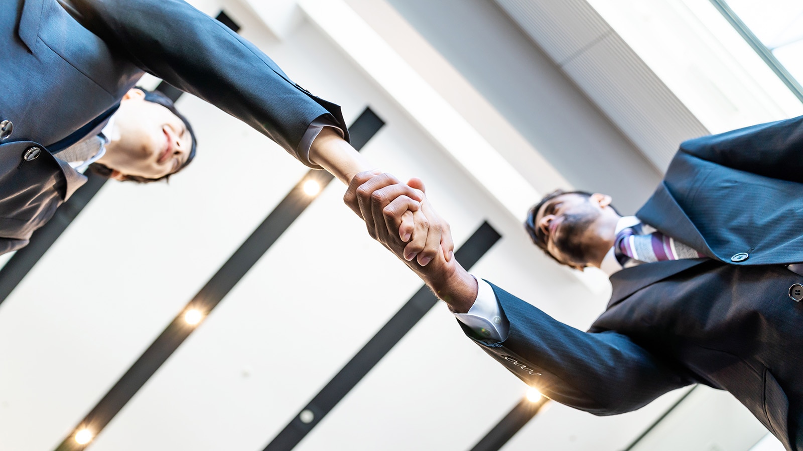 日本人と外国籍ビジネスマンが握手をしている様子