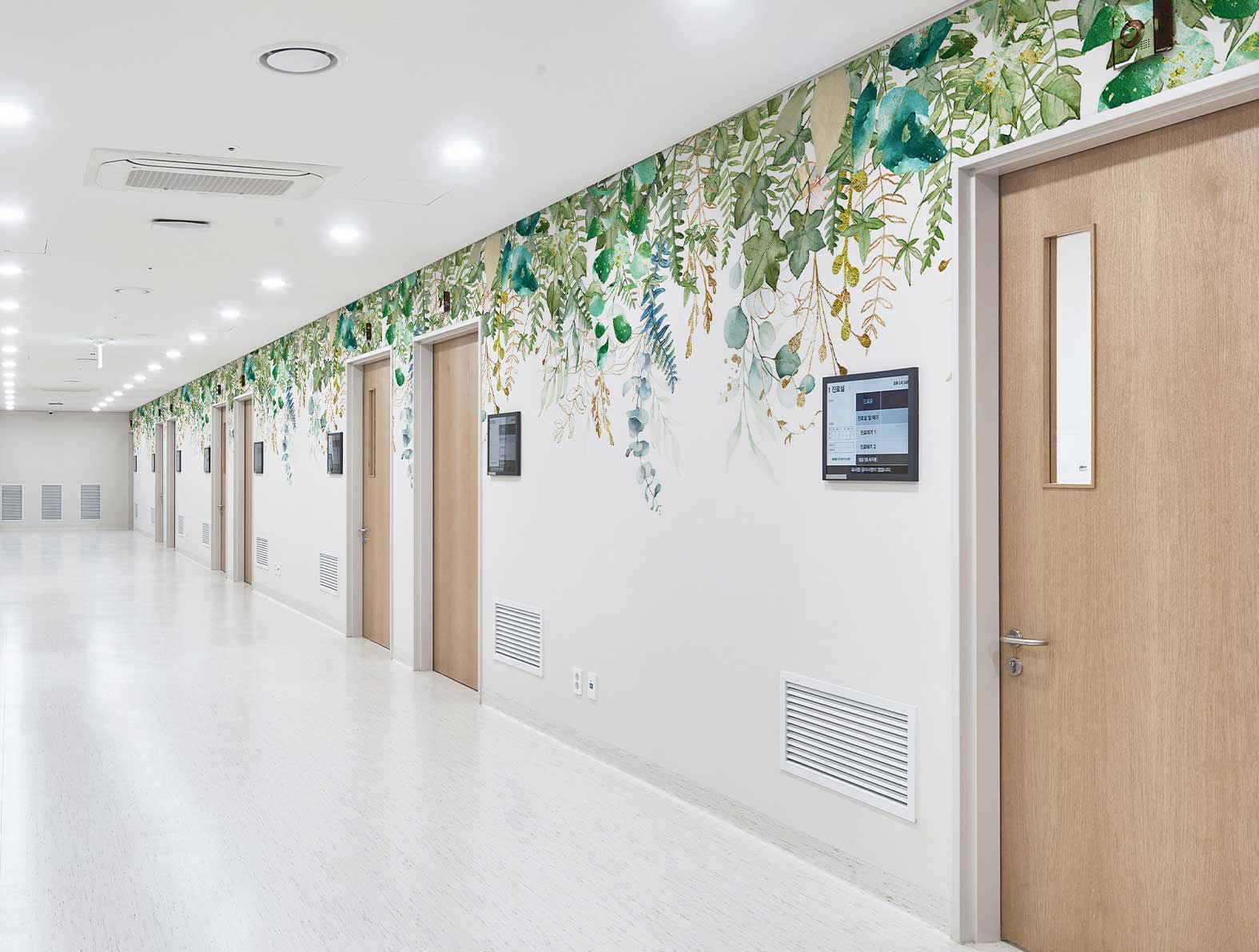 病院の通路に綺麗めのグリーン壁紙
