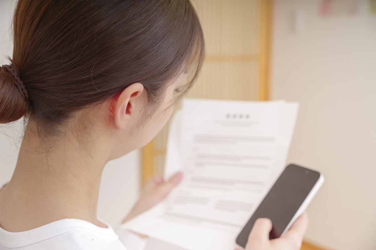 家賃値上げ通知書を開封する女性