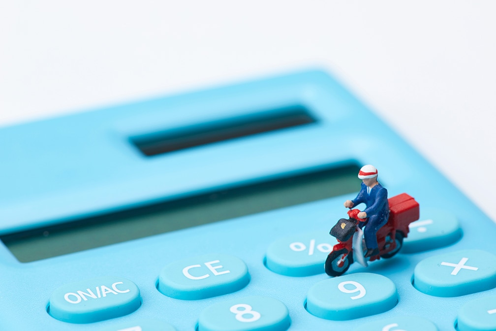 電卓と配達員の写真