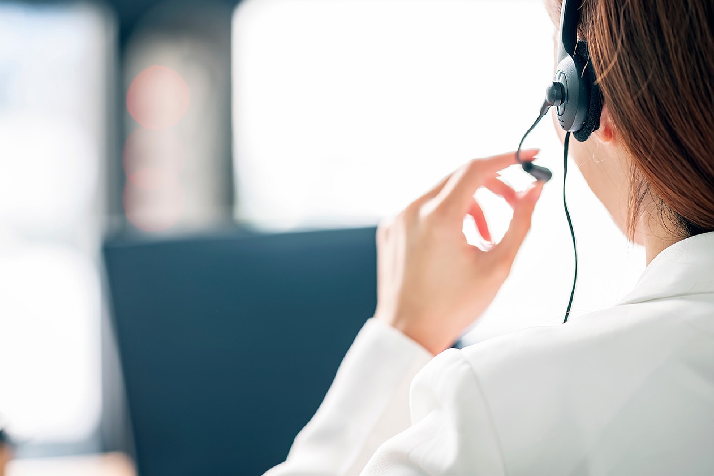 ヘッドセットを付けた女性の後ろ姿