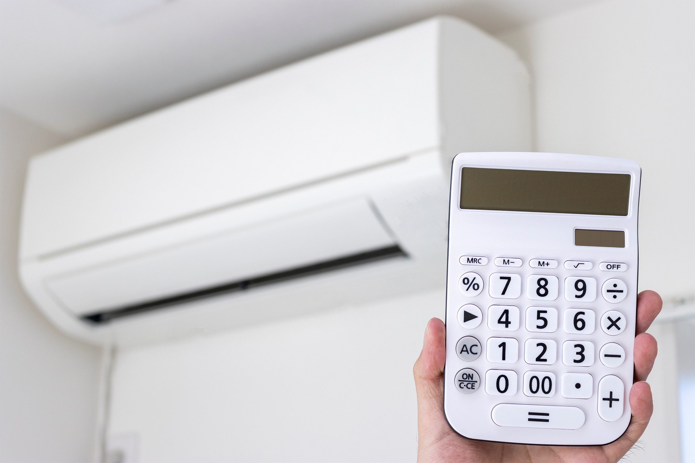 エアコンと電卓をもった手