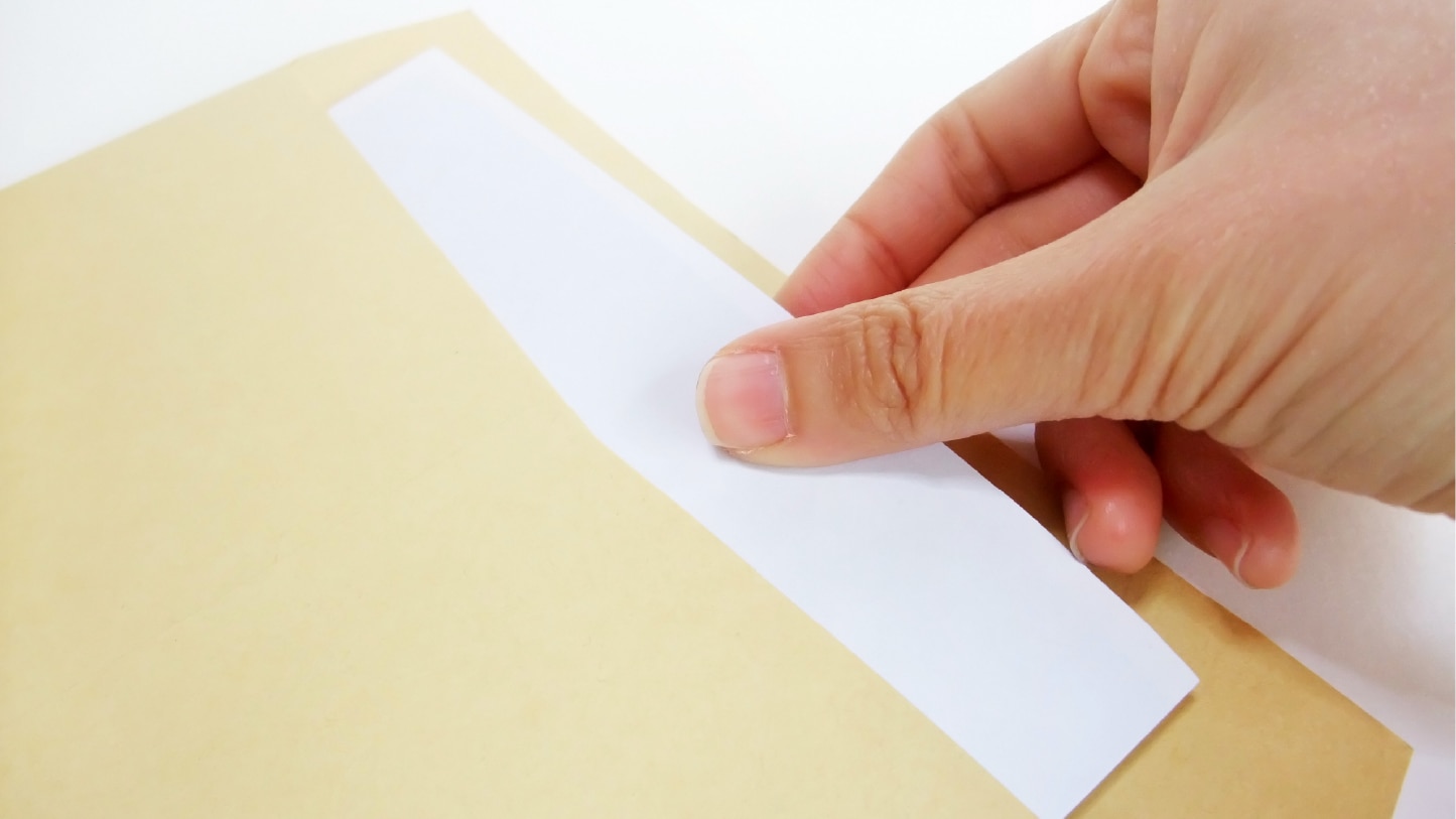 茶封筒から紙を取り出す手元