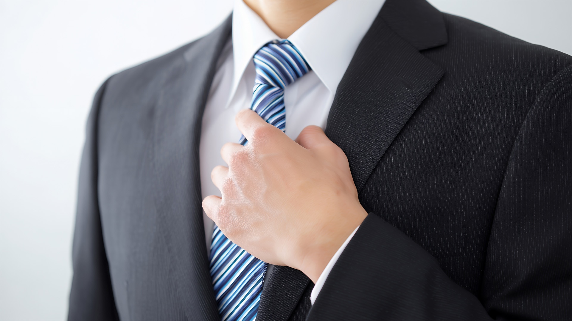 男性がネクタイを締めて身だしなみを整えている様子