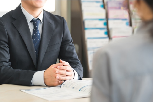 保険の案内をする男性と話を聞く女性