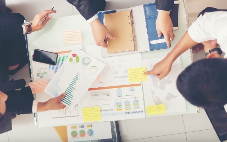 資料を確認しながら業務改善を検討するチーム