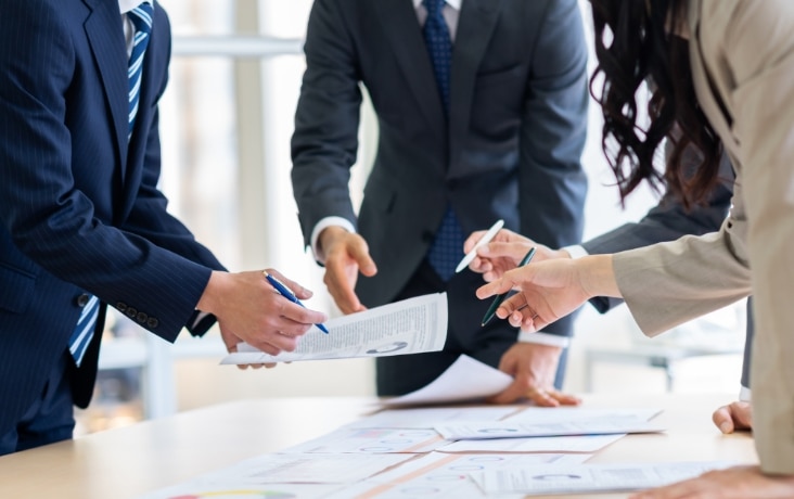 資料を確認しながら打ち合わせを行うビジネス担当者