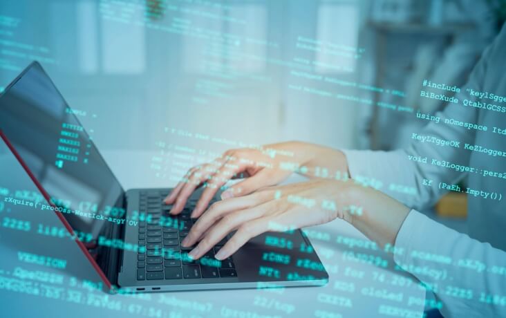 ノートPCでプログラミング作業を行うエンジニア