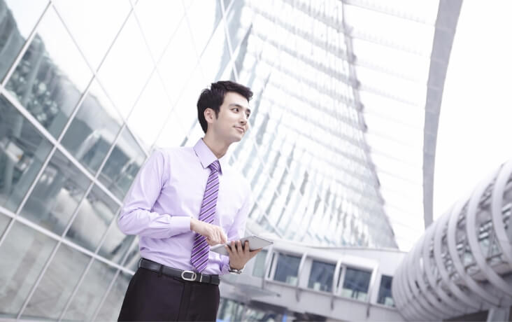 オフィス街でタブレットを確認するビジネスパーソン