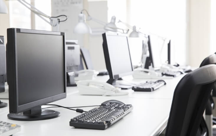 オフィスに設置されたデスクトップPCと業務環境