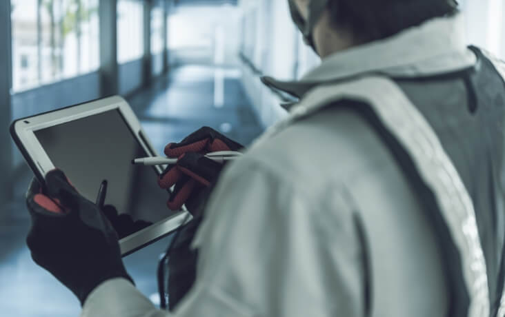 タブレットを使用して設備点検を行う作業員