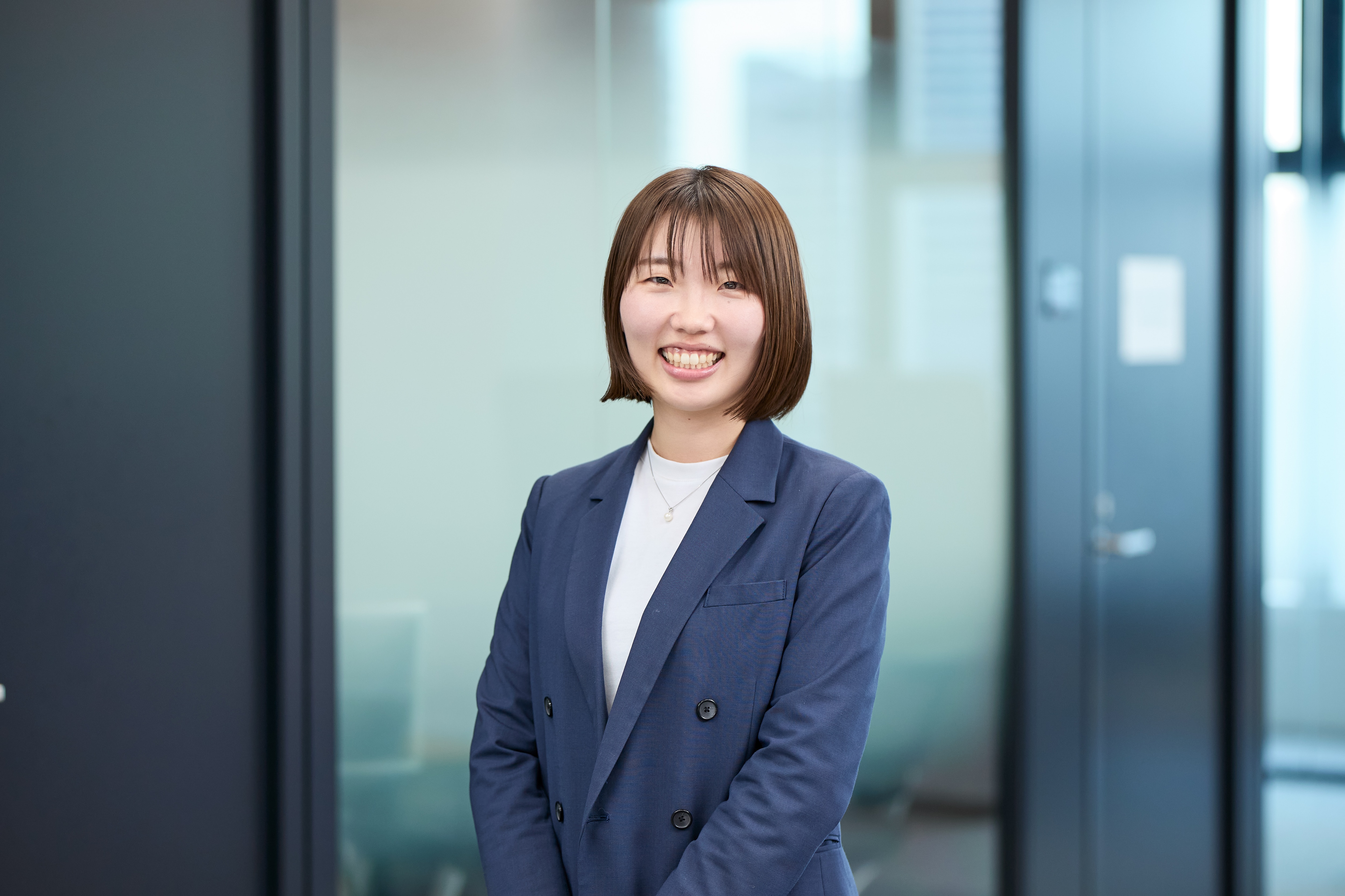 浜離宮ザタワーにあるオフィス内で立っている、メッドコミュニケーション事業部のH.Nさん