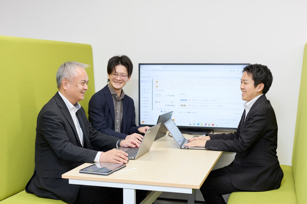 freeeの操作画面を囲みながら談笑する加藤氏、木村氏ら3名