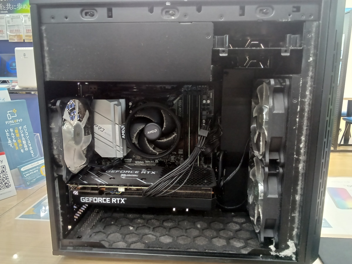 クリーニング前のパソコン内部。吸気ファンや排気ファン、CPUクーラー周辺、ケース右側のフレームに白い埃がびっしりと付着しているのが分かります。